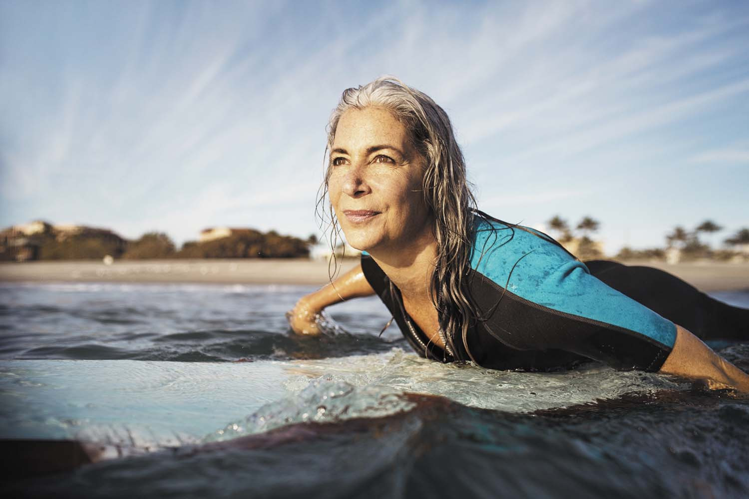 photo of a mature woman in the ocean body surfing