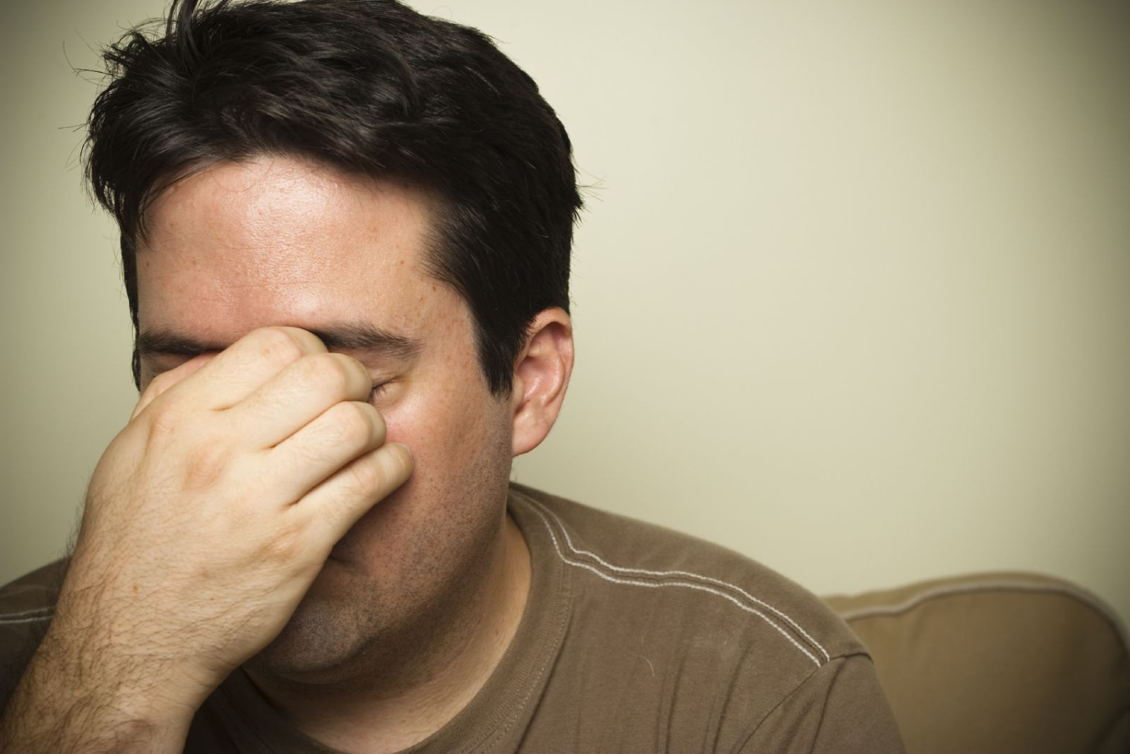 Man holds his nose because of sinus pain or headache.