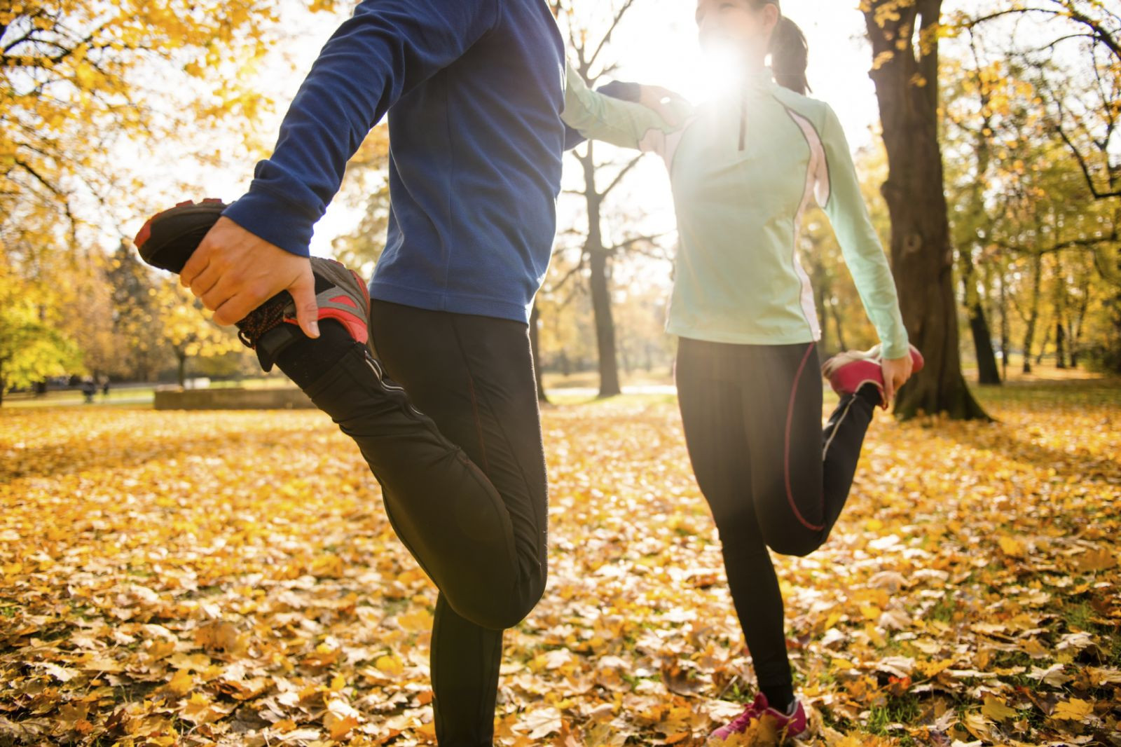 Two adults stretching out their legs outdoors