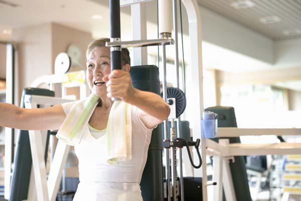 photo of a senior woman using an exercise machine in a gym