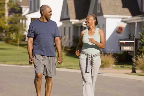 photo of a mature couple walking on a sunny day in a pleasant neighborhood