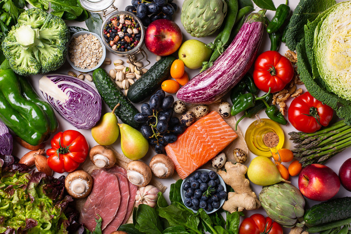 Szereg kolorowych produktów spożywczych występujących w diecie śródziemnomorskiej, w tym warzywa, owoce, orzechy, zboża, ryby, oliwa z oliwek i mięso.